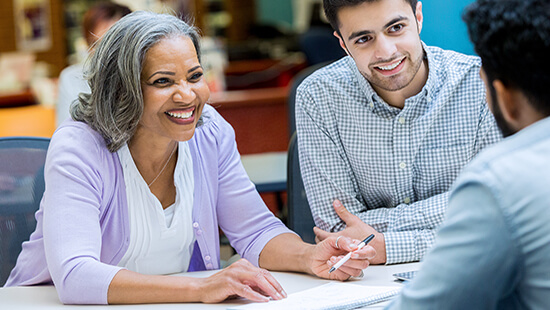 Two business professionals talking to a person.